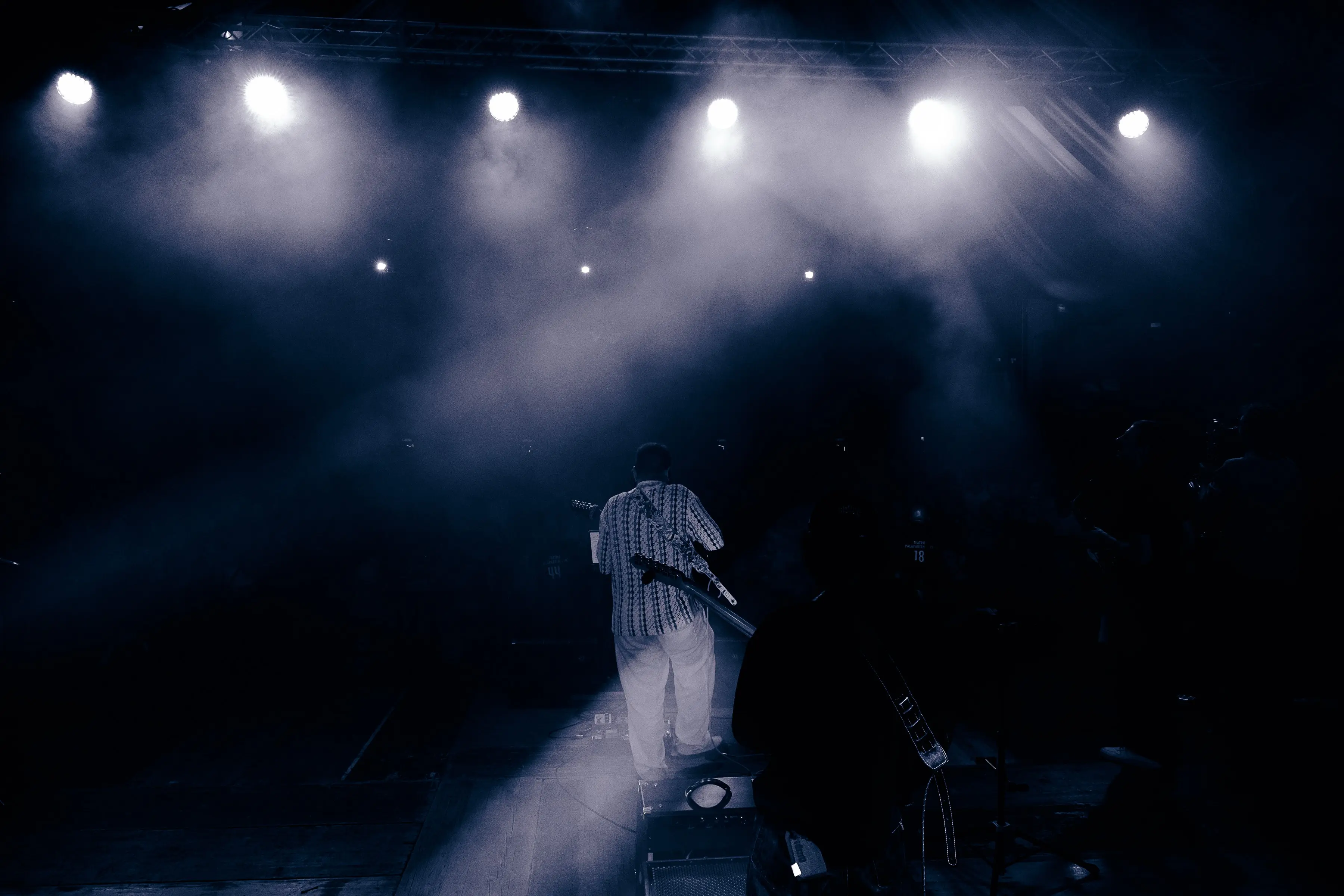 Silhouette of a guitarist performing under bright stage spotlights